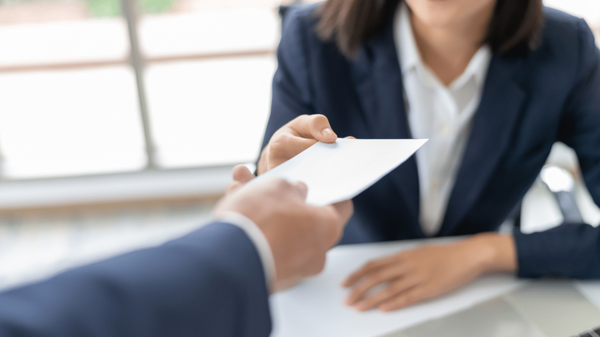A hiring manager handing out the newly-hired employee a signing bonus
