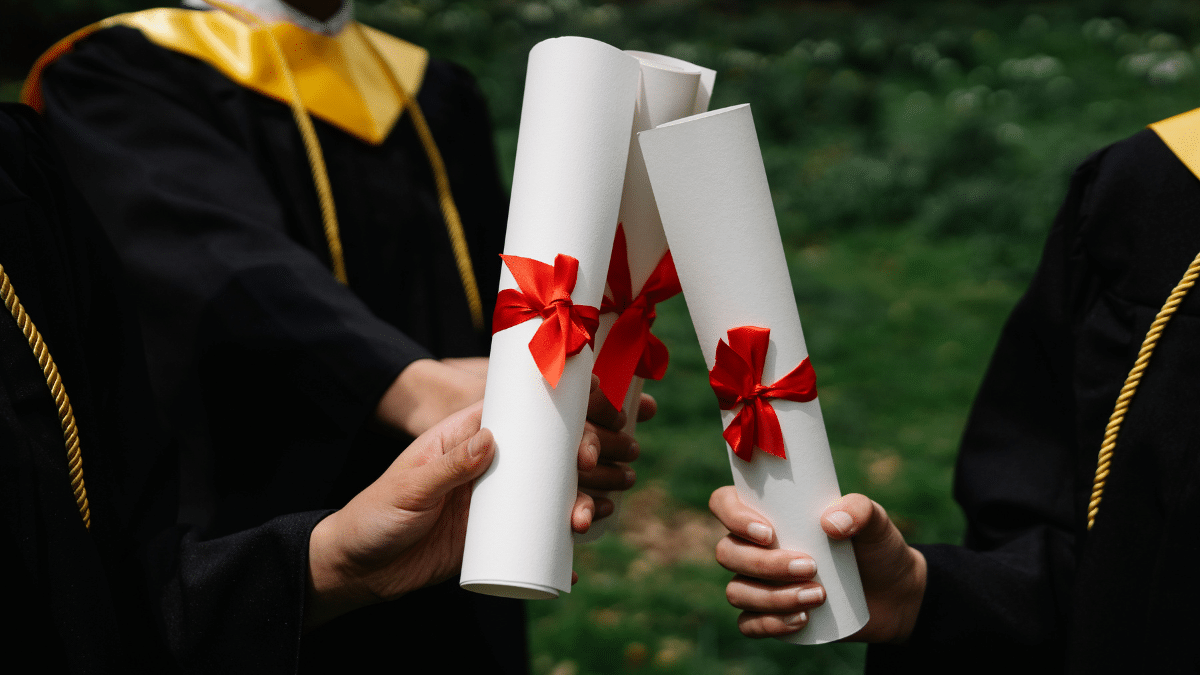 Three college graduates holding their diploma